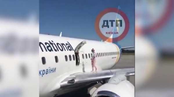 На Украине женщина залезла на крыло самолета0