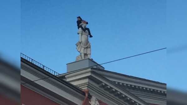 Петербуржец залез на голову статуи на крыше дома Невского проспекта